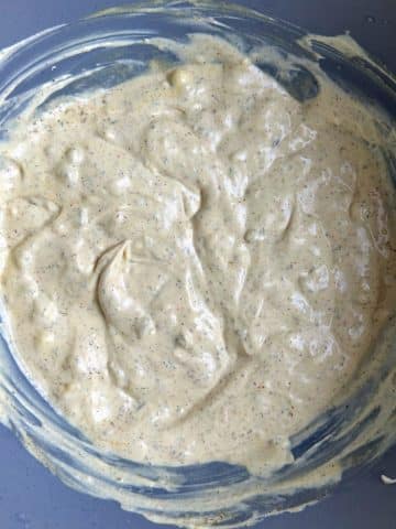 A bowl of mayonnaise dressing with spices.