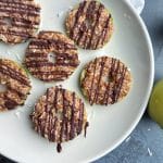 A white plate containing Samoa Coconut & Date Caramel apples with a chocolate drizzle.
