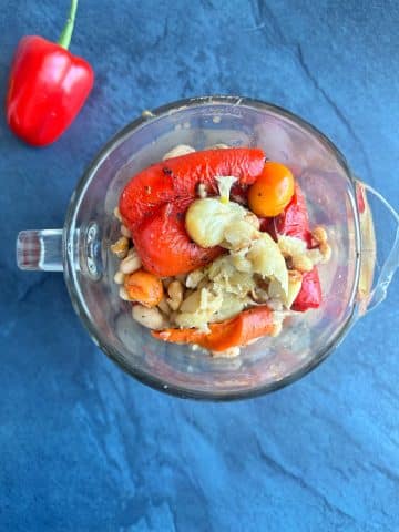 Roasted vegetables inside a clear blender.
