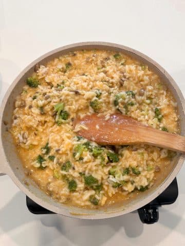 A pan filled with unbaked broccoli rice casserole.