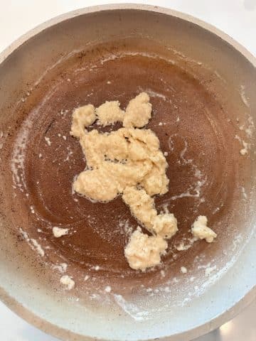 A saucepan with a flour and butter roux in the middle.