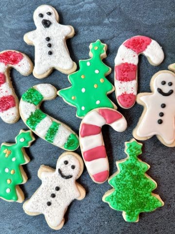 Multiple Christmas-decorated sugar cookies laid out on display.