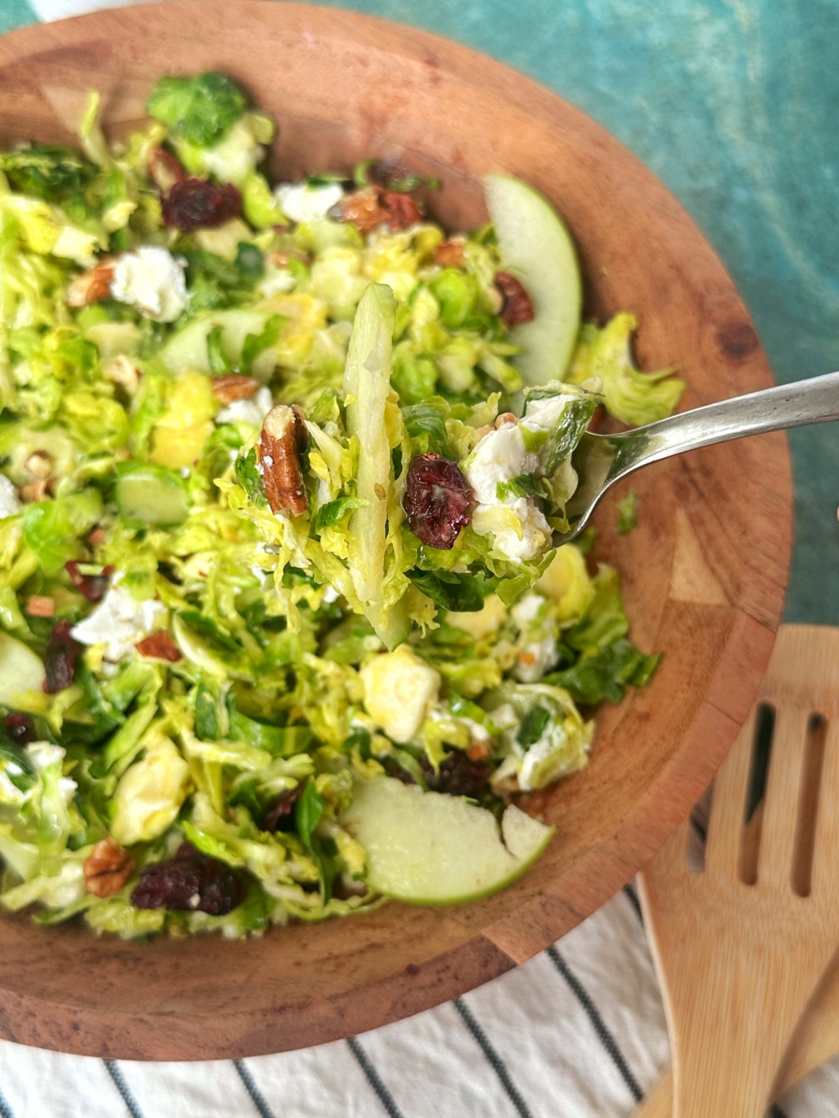 A fork holding up a forkful of shredded brussels sprouts salad.