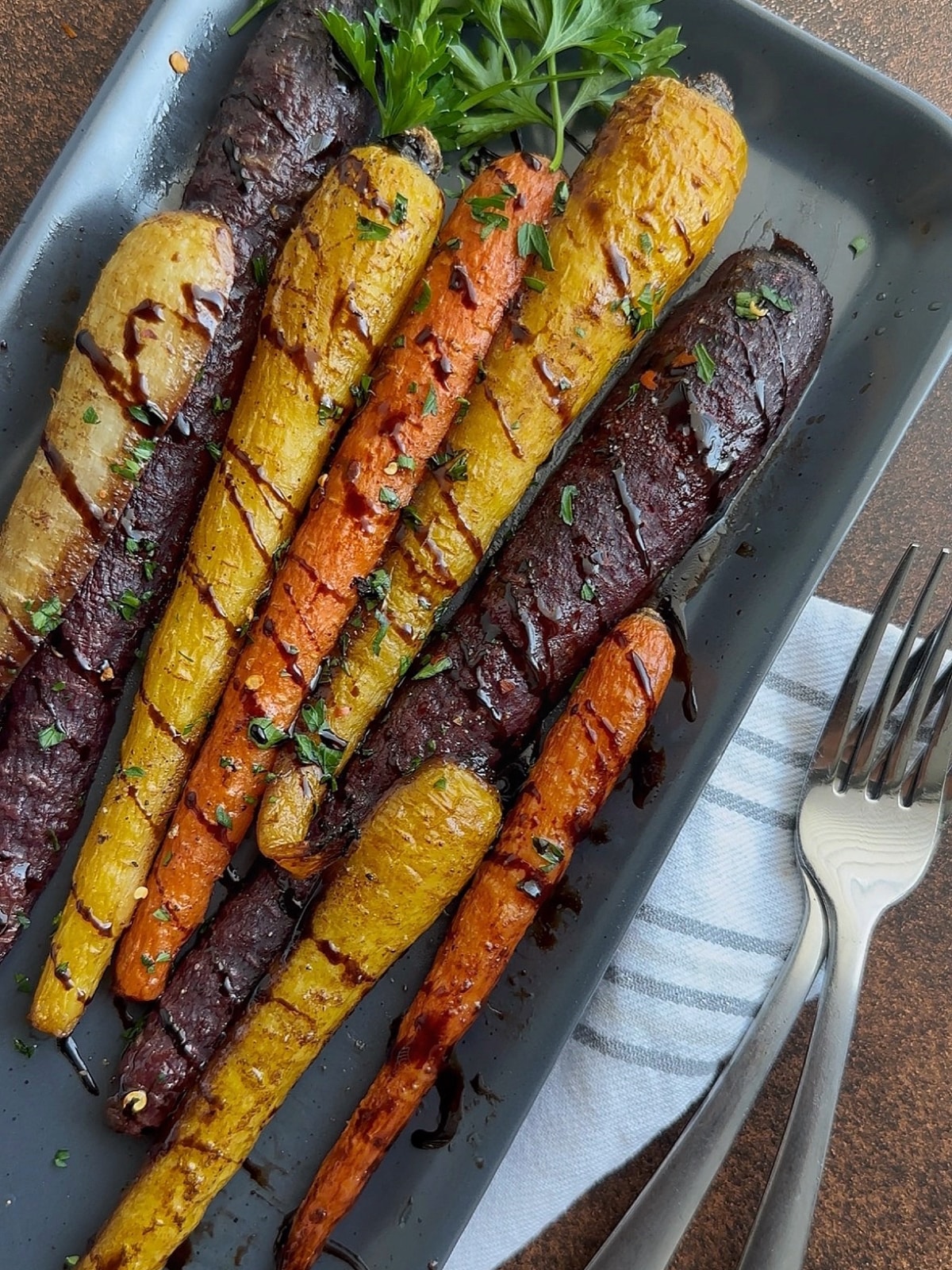 A tray of roasted rainbow carrots with balsamic glaze drizzled on top.