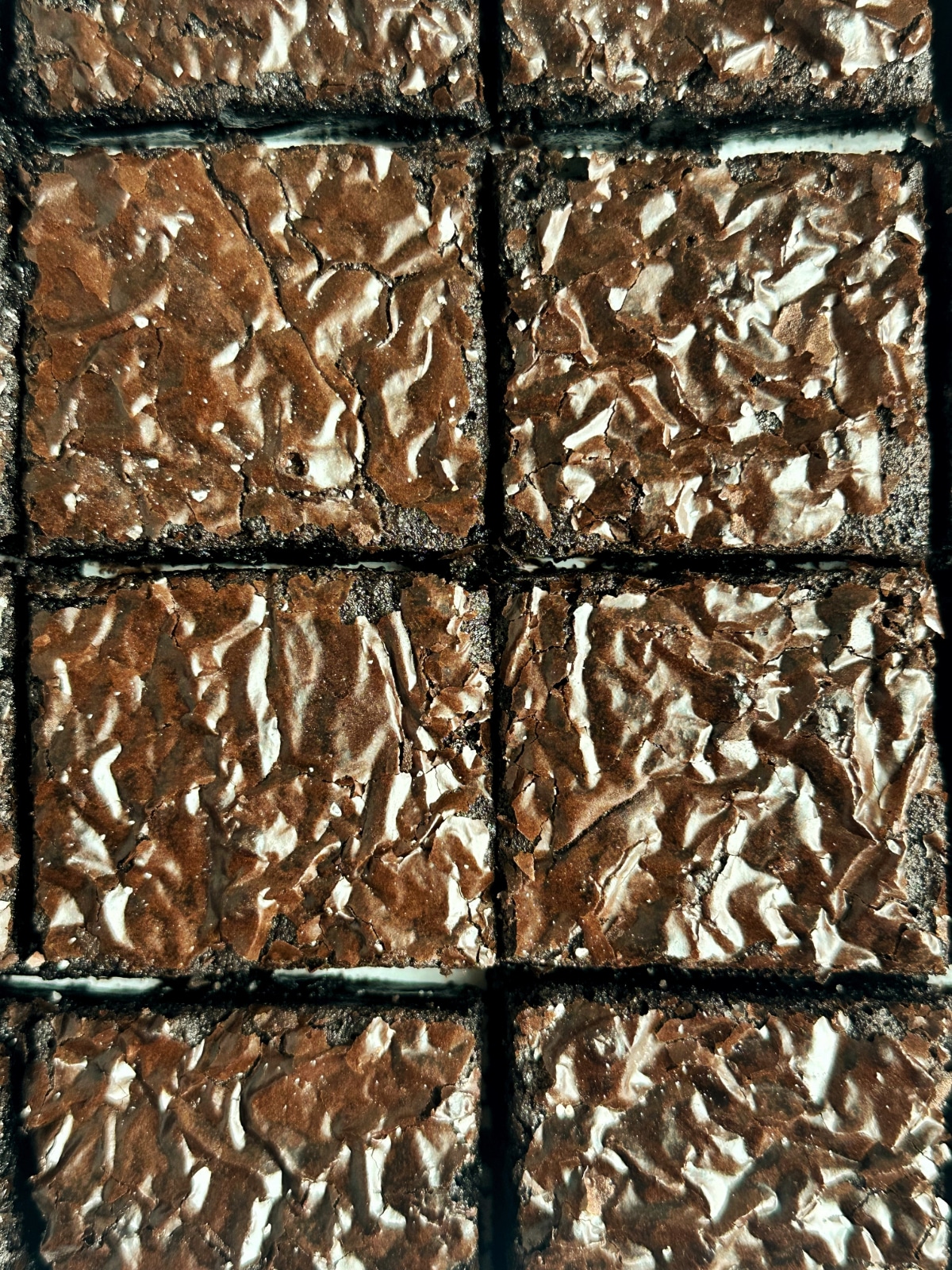 An overhead shot of a pan of cut crinkle top brownies.