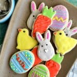 A plate filled with cut out sugar cookies decorated for Easter.