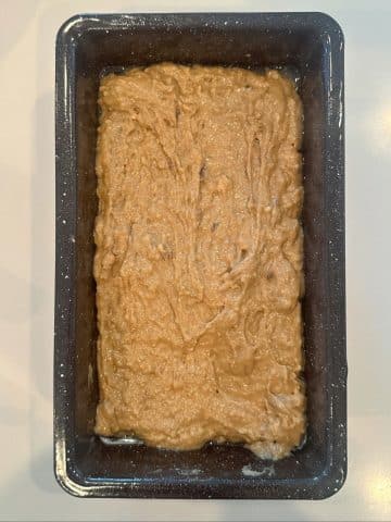 A loaf pan filled with espresso-flavored banana bread batter.