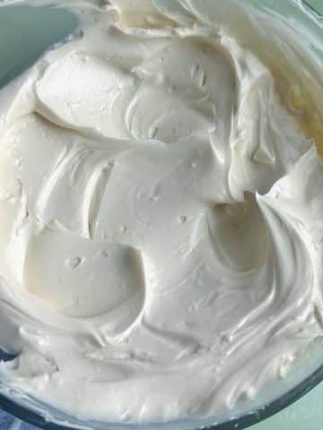 A bowl of homemade white buttercream with medium peaks.