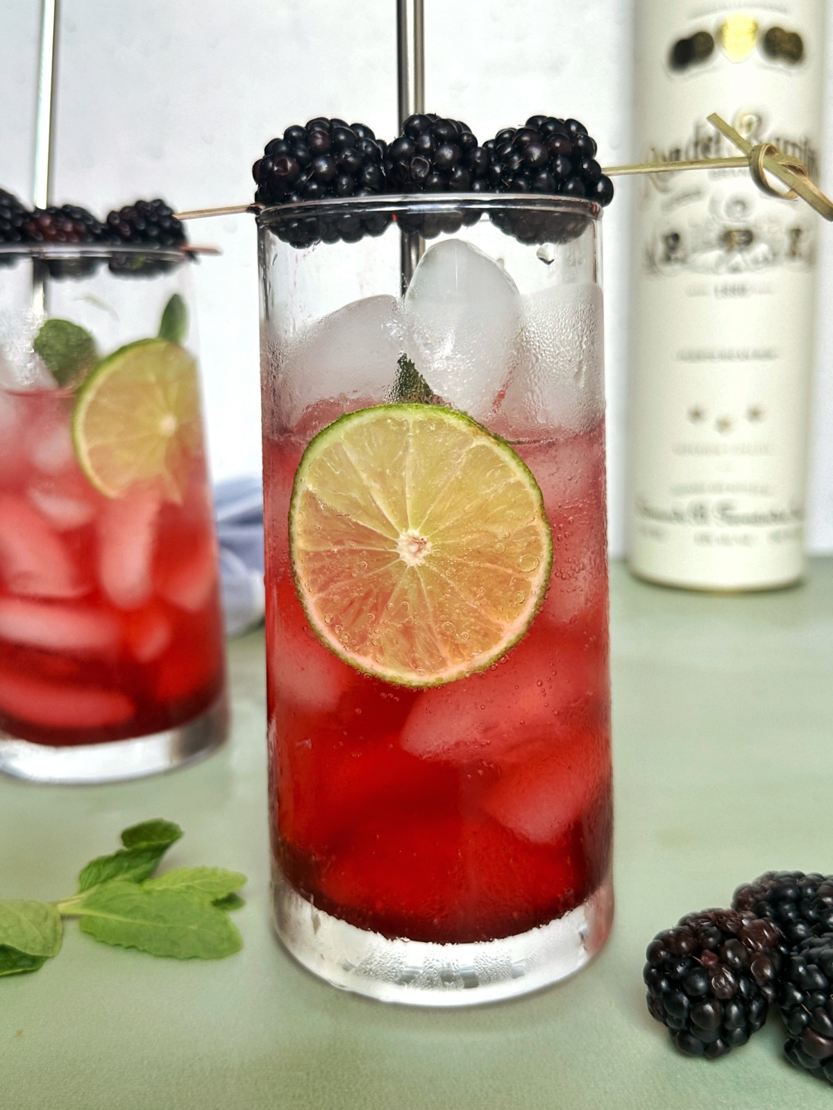 A glass of reddish-purple colored mocktail served over ice.