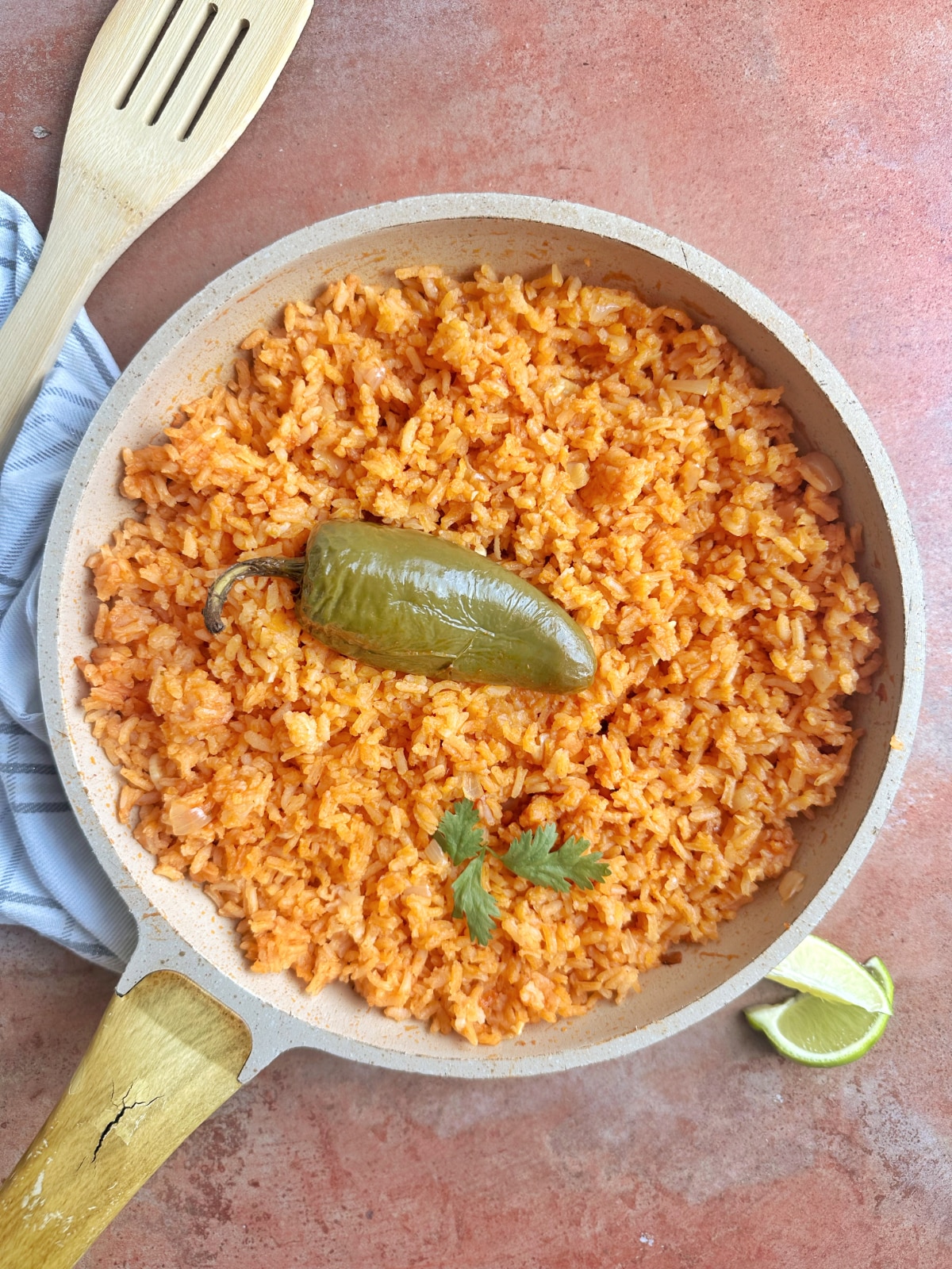 A pot filled with red Mexican Rice and a whole jalapeño in the middle.
