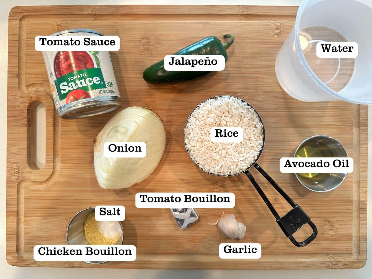 A wooden board containing bowls with ingredients for arroz Rojo
