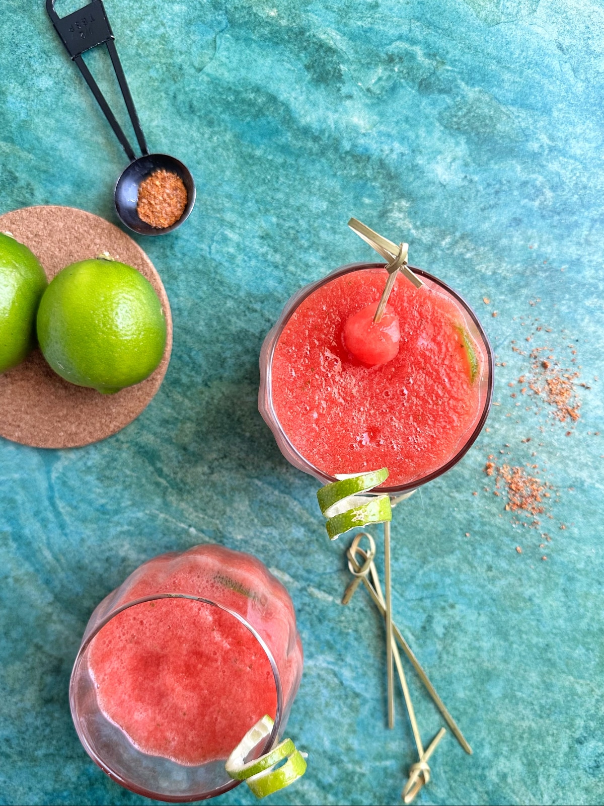 An overhead shot of two glasses filled with watermelon refresher drink.