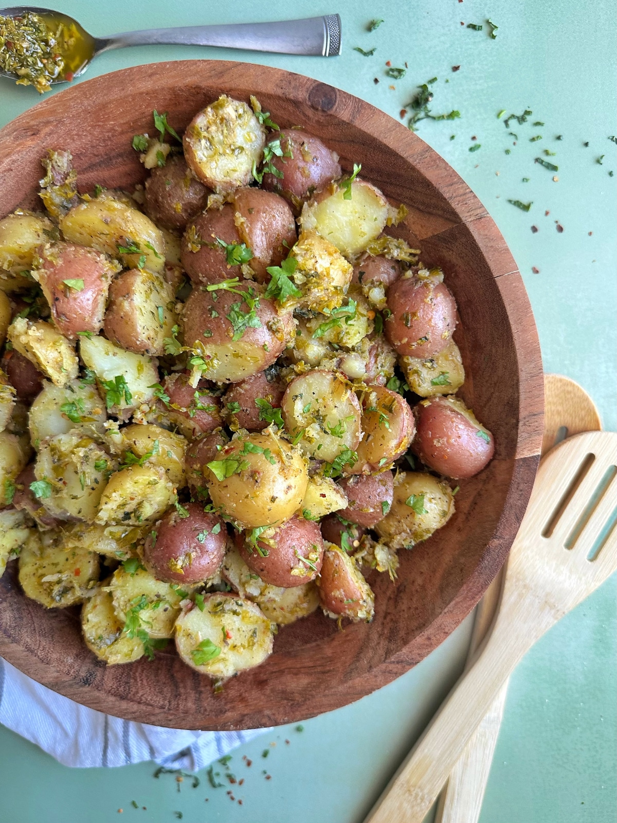 A brown wooden bowl filled with homemade chimichurri potato salad.