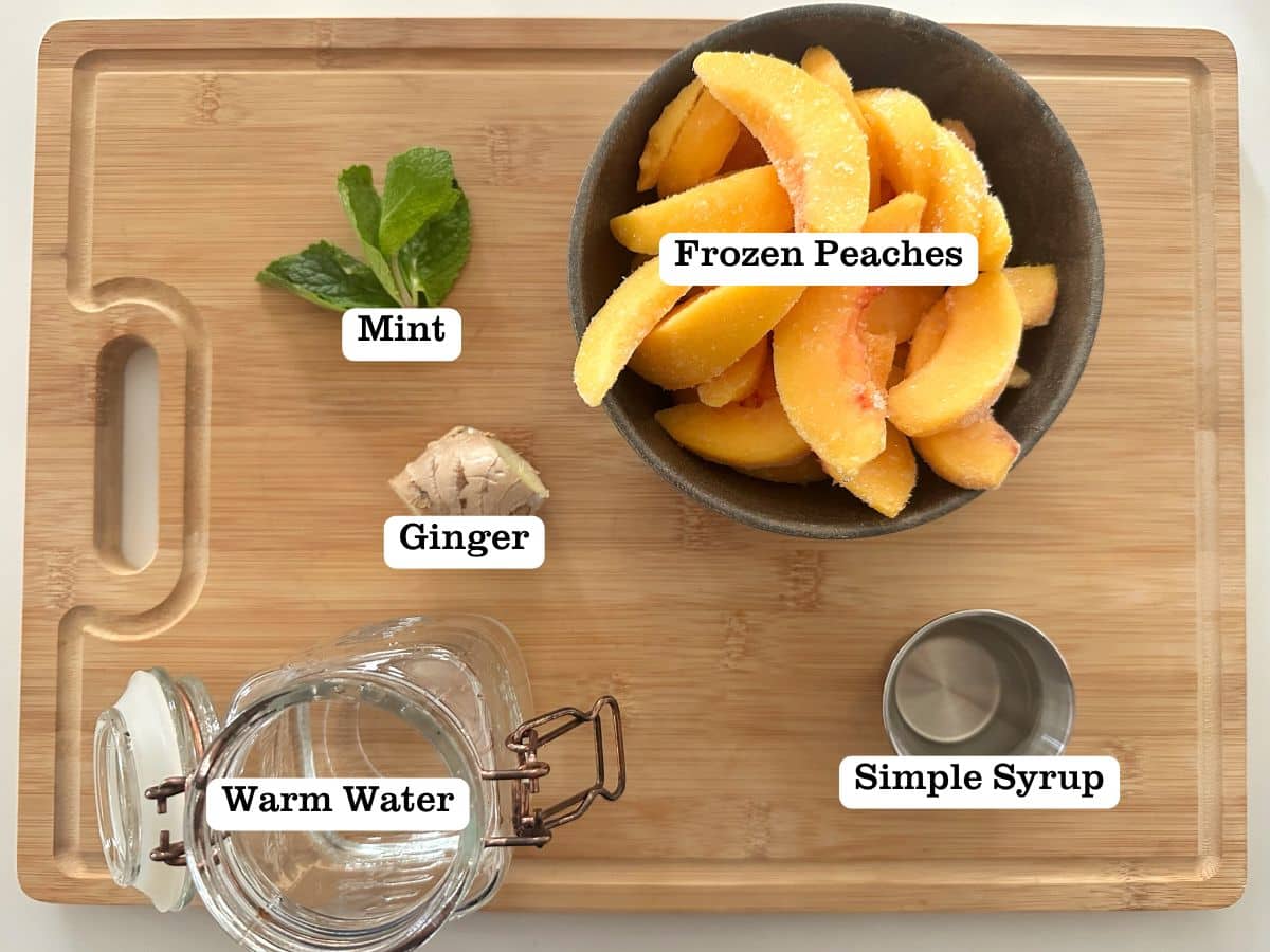 A wooden board containing bowls of ingredients for peach ginger sorbet made at home.