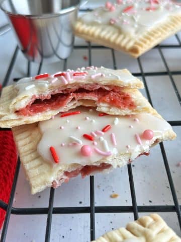 A shot of homemade strawberry pop tarts cut in half and stacked on top of each other to show the inside texture.