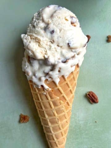 A waffle cone filled with homemade butter pecan praline ice cream.