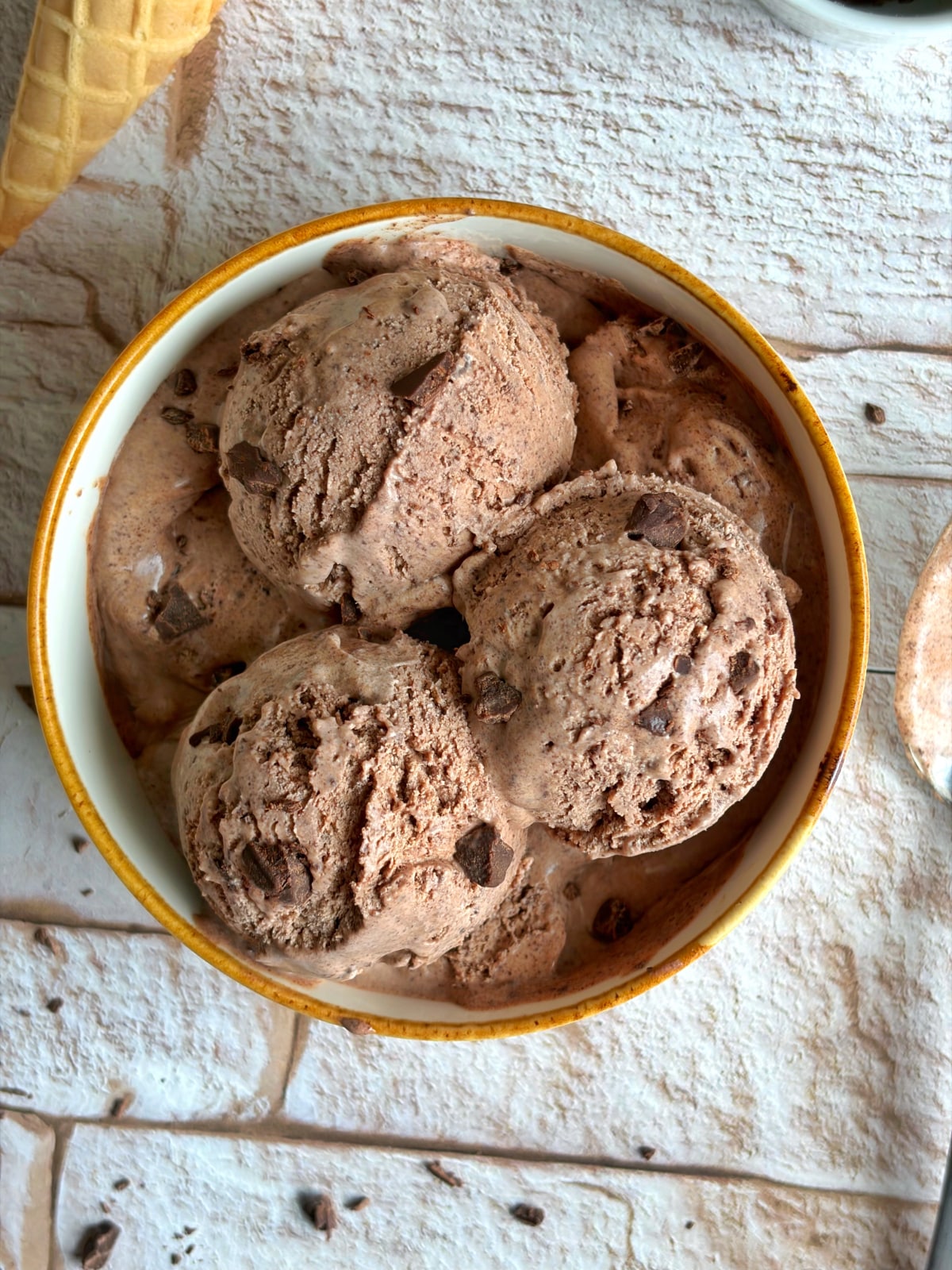 A bowl of dark chocolate ice cream with chopped chocolate mix-ins.