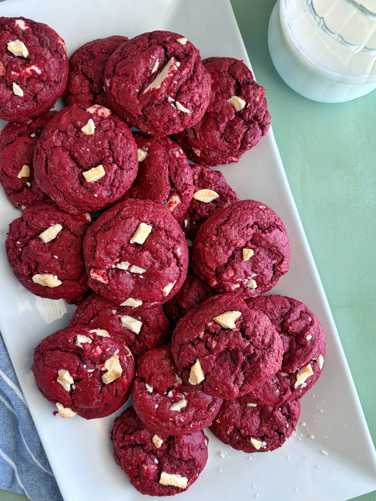 A tray of red velvet cake mix cookies with a glass of milk.