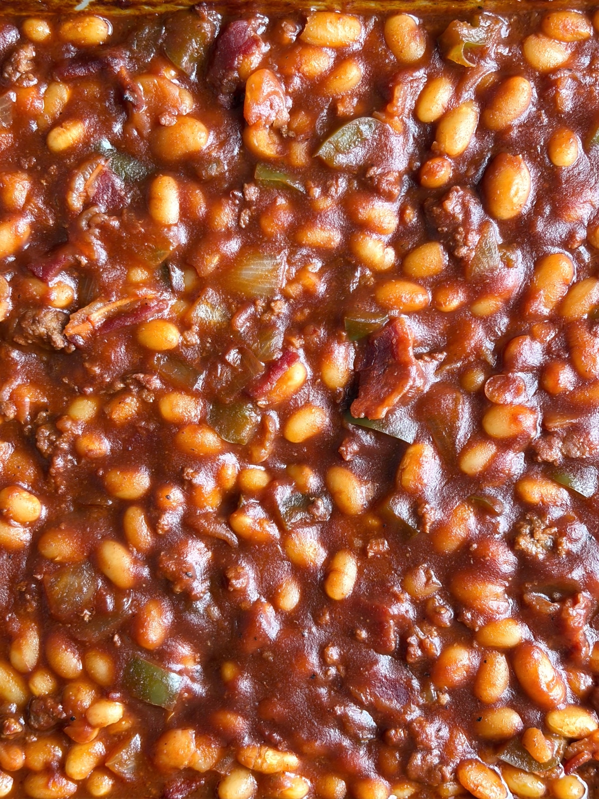 A closeup shot of a pan of southern barbecue baked beans.