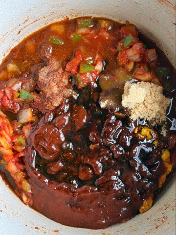 A Dutch oven filled with ingredients for homemade barbecue sauce.
