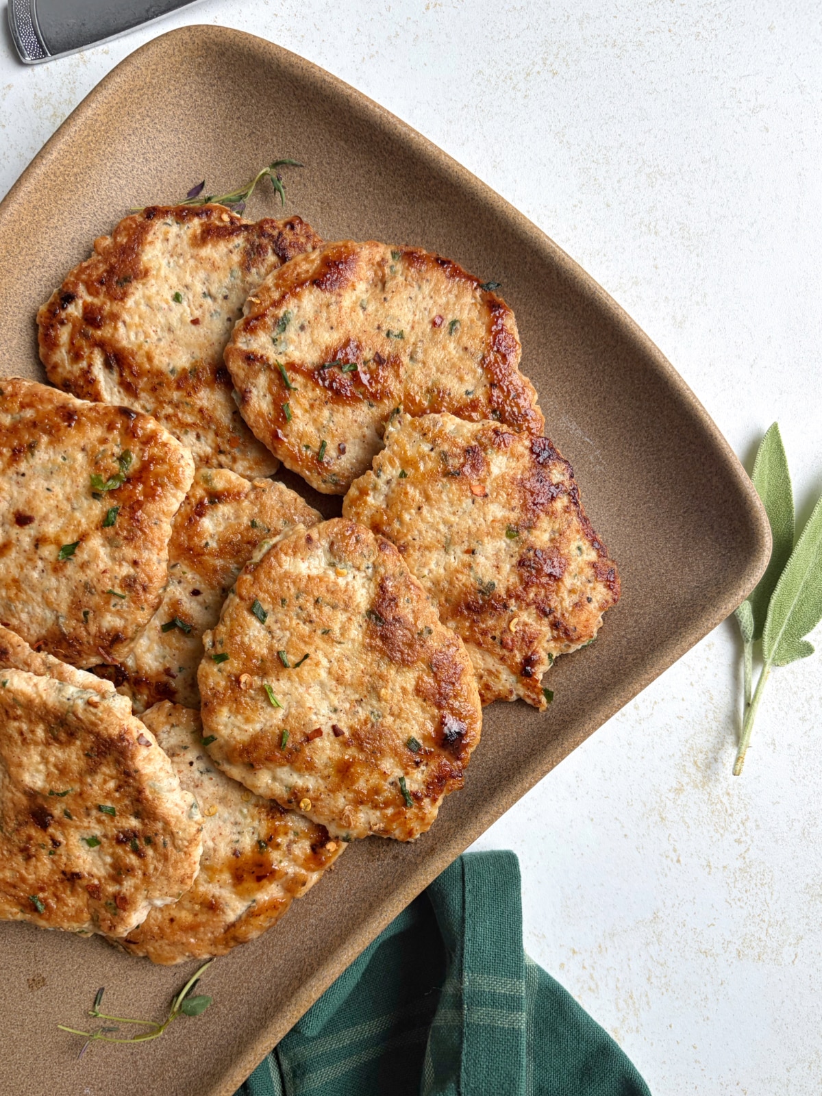 A plate with stacks of seared chicken sausage patties.