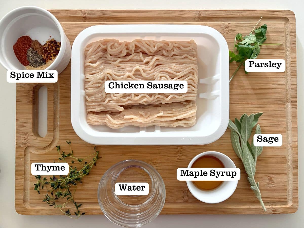 A wooden board with containers of ingredients to make breakfast sausage with ground chicken.