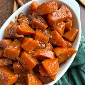 A white ceramic dish filled with candied yams.