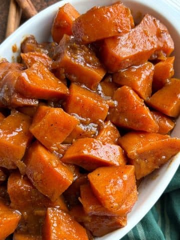 A white ceramic dish filled with candied yams.
