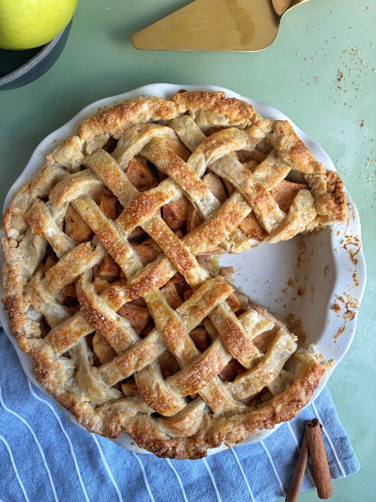 A classic apple pie with a slice cut out of it.