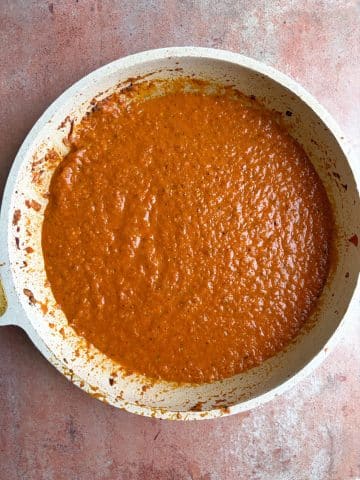 A skillet with savory tomato sauce inside.