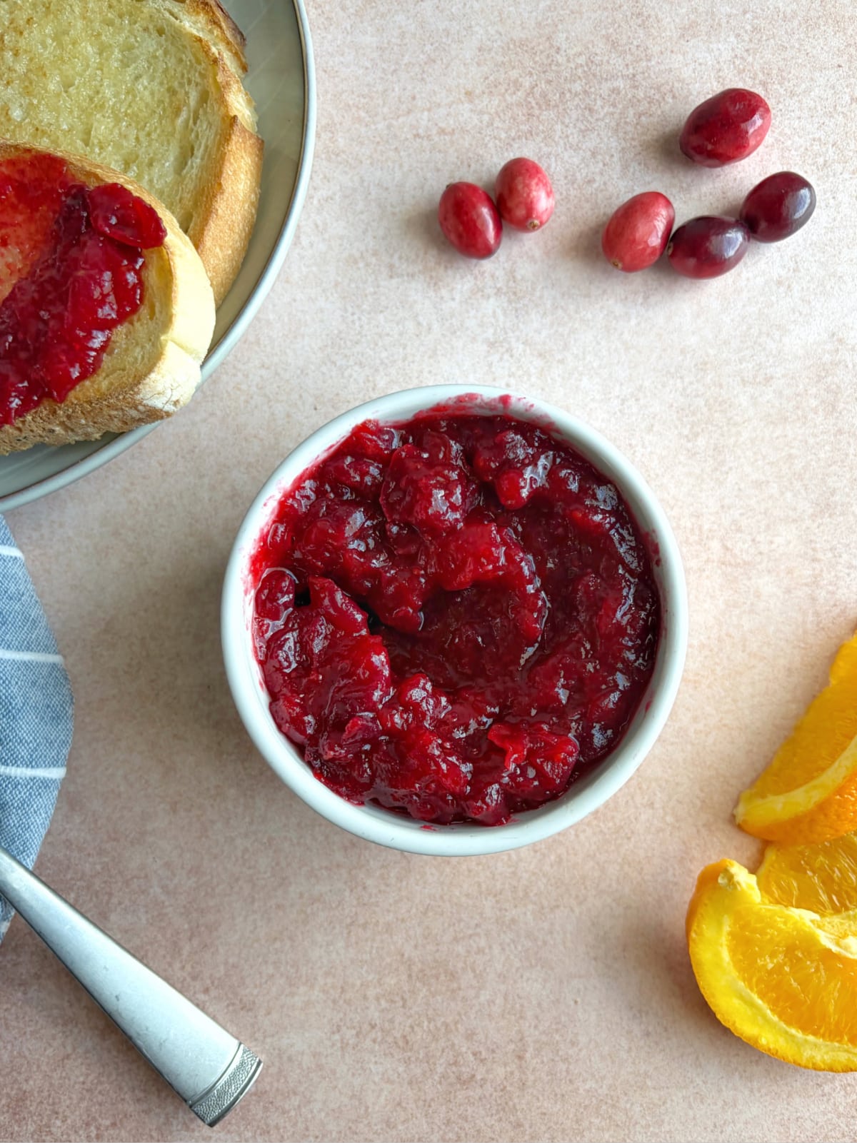 A sauce bowl filled with orange cranberry jam, with toast on the side.