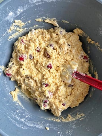 A mixing bowl filled with muffin batter and a silicone spatula.