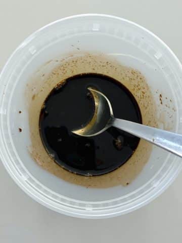 A deil container filled with soy sauce, oyster sauce, and brown sugar.