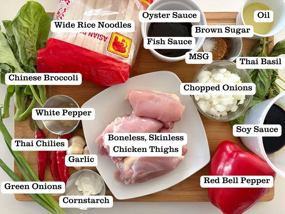 A wooden board with containers for ingredients to make Chicken Pad Kee Mao, or Drunken Noodles.